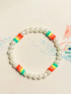 Stretchy handmade clay beaded bracelet with pearls surrounding every little neon rainbow. I love this bracelet so much it's so cute and could literally go with anything. Clay Bead Bracelet Ideas, Bracelet Preppy, Bead Bracelet Ideas, Sea Beads, Bracelet With Pearls, Diy Friendship Bracelets Tutorial