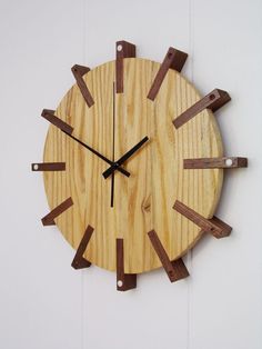 a clock made out of wood with nails stuck in it