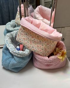 three small storage bags sitting on top of a counter next to each other, one filled with makeup and the other closed