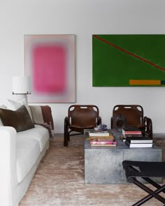 a living room with two couches and a coffee table in front of a painting