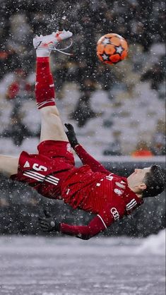 a soccer player is in the air catching a ball