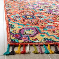 a colorful rug with tassels on the floor