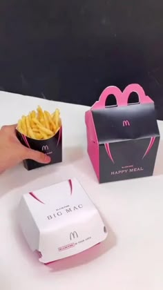 a hand holding a box of fries next to a mcdonald's bag