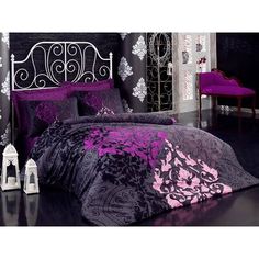 a bed with purple and black comforters in a room