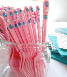 pink and blue toothbrushes sitting in a glass vase on top of a table