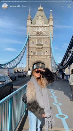 a woman is standing in front of the tower bridge