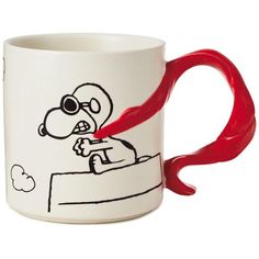 a coffee mug with a red handle and cartoon drawing on the inside, in front of a white background