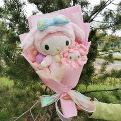 a person holding a hello kitty bouquet in their hand and wearing a pink outfit on it