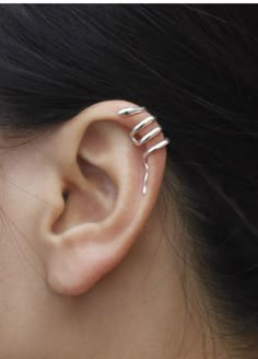 a woman's ear with three silver spirals on it