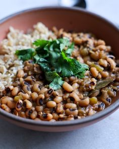 a bowl filled with rice, beans and cilantro on top of a table