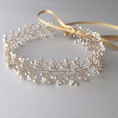 a gold headband with white flowers and pearls