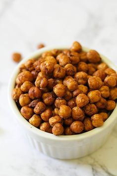 a white bowl filled with nuts on top of a table