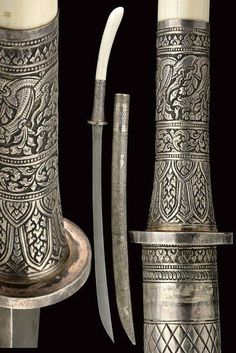 an ornate silver vase with two knives in it