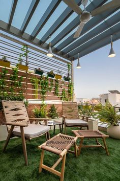 an outdoor patio with wooden furniture and potted plants on the roof top deck area