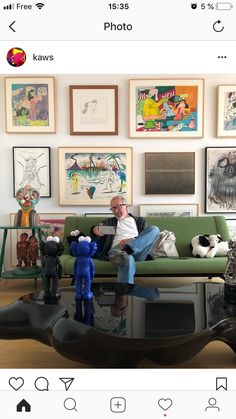 a man sitting on top of a green couch next to a table with toys in front of him