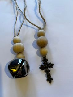 the beads are attached to the bell with a cross hanging from it's side