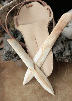 a pair of scissors sitting on top of a piece of leather next to a rock