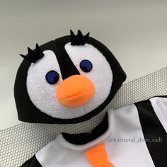 a stuffed penguin wearing a referee's uniform