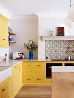 a kitchen with yellow cabinets and white counter tops is seen in this image from the front view