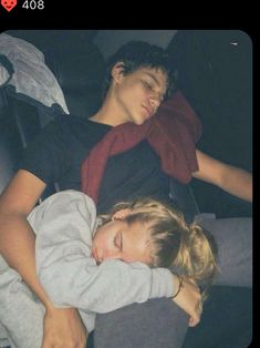 two children sleeping on a bed with one holding the other's arm around his neck