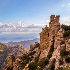 the rocky mountains are covered in vegetation and rocks, with blue skies above them on a sunny day