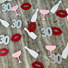 paper cut out numbers and lipstick on the ground with wine glasses in front of them