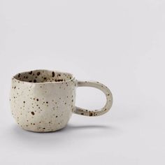 a white and brown speckled coffee cup