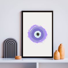 a framed poster with an eyeball on it next to two vases and a radiator