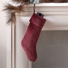 a red christmas stocking hanging from a mantel