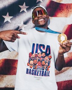 a man holding a gold medal in front of an american flag with his hand pointing to the side