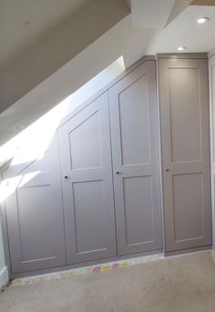 an empty room with white cupboards in the wall and carpeted flooring on the ground