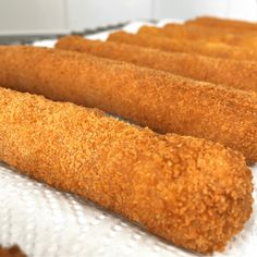 some fried food sticks are on a white tray and ready to be cooked in the oven