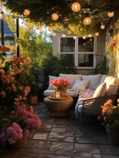 an outdoor seating area with flowers and lanterns