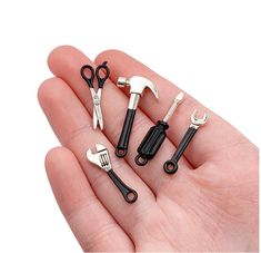 five miniature tools are in the palm of someone's hand