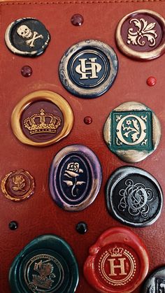 several different colored wax seals on a red leather case