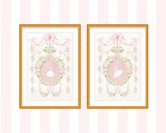 two framed pictures with pink and gold trimmings on the wall next to each other