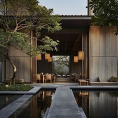 an outdoor dining area with tables and chairs next to a pond in the middle of it