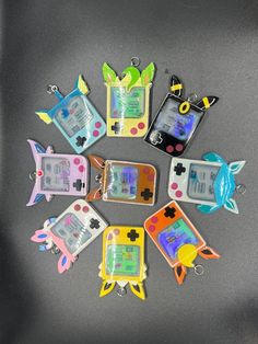 a group of nintendo gameboy keychains sitting on top of a black table