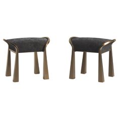 two modern chairs with metal legs and black upholstered fabric, one is gold