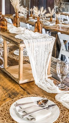 the table is set with white plates and silverware