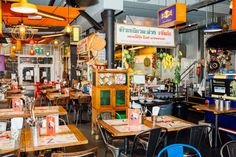 the inside of a restaurant with many tables and chairs around it, all decorated in different colors