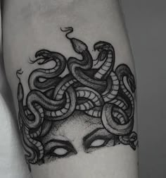 a woman's arm with a snake tattoo on it