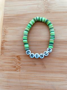 a green and white beaded bracelet with the word grin spelled in small letters on it