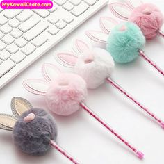 four bunny ears hair pins on top of a desk next to a keyboard and mouse