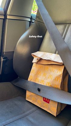 a bag sitting in the back seat of a car with safety first written on it