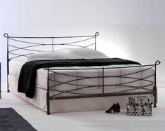 a bed that is sitting on top of a white floor next to a black rug