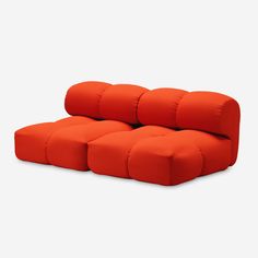 an orange couch sitting on top of a white floor