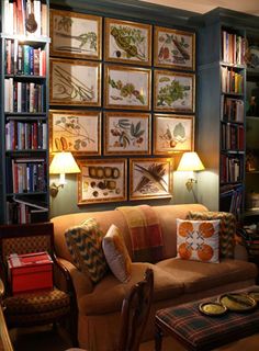 a living room filled with lots of furniture and pictures on the wall above it's couches