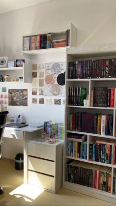 a white bookcase filled with lots of books next to a computer desk and chair