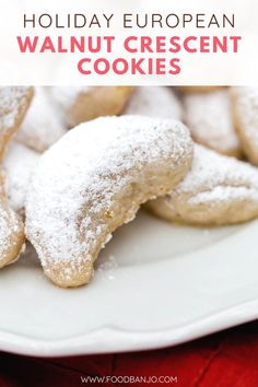 a white plate topped with cookies covered in powdered sugar on top of a red table cloth